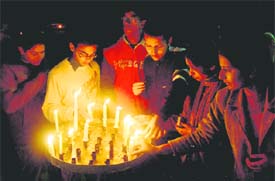 devotees light candles ar St Francis church.