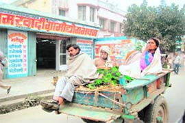 A family wrapped in warm clothes rides home in Kashipur
