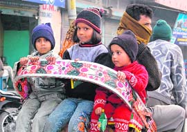 Wrapped in woollens, a family takes a rickshaw ride at Kashipur in Udham Singh Nagar.