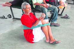 A coolie holds his back with a piece of cloth at the Dehradun railway station on Tuesday.