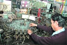 A worker at the Anand Industries, Dehradun, make miniature bulbs.