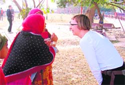 A foreigner interacts with two Rajasthani women in Haridwar.