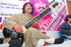Surmani Agni Verma prepares for sitar recital. 