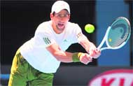 Novak Djokovic of Serbia returns the ball to Amer Delic (inset) of the US during singles match.