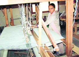 A village woman works on a handloom