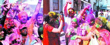 (Left) MP Navjot Singh Sidhu in swinging mood with his supporters and people celebrate Holi in Amritsar on Tuesday.