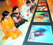 People watch Rangoli on the theme of Mumbai terrorist attacks, by artists from Maharashtra.