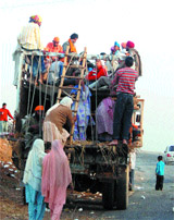 People board a truck to reach Anandpur Sahib to participate in Hola Mohalla in Amritsar on Tuesday.