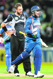 Virender Sehwag (R) celebrates scoring his century as New Zealand captain Daniel Vettori looks dejected during the fourth one-day international in Hamilton.