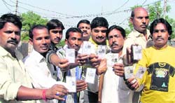 Slum dwellers with their voter ID cards in Ludhiana