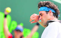 Roger Federer of Switzerland cleans his face during semi-final match against Novak Djokovic. Djokovic beat world number two Federer 3-6 6-2 6-3.