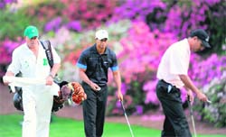 Tiger Woods (centre) of the US and India�s Jeev Milkha Singh (right) prepare for a putt on the thirteenth green during the first round of the US Masters at the Augusta National Golf Club on Thursday.