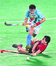 Malaysian player Mohammad Sharun Nabil (bottom) dives to stop Tushar Khandker of India during the final of the Sultan Azlan Shah Cup field hockey match.