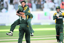 Shahid Afridi (C) of Pakistan celebrates with Shoaib Akhtar (L) as Kamran Akmal (R) looks on during their first one day international match against Australia in Dubai, on Wednesday.