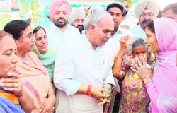 Congress nominee Mohinder Singh Kaypee is greeted by a voter in Adampur village near Jalandhar