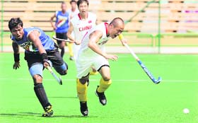 China's Na Yubo (R) races for the ball with India's Dilip Tirkey during the Asia Cup