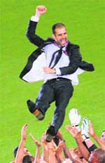 ON CLOUD NINE: Barcelona coach Pep Guardiola is thrown in the air at the end of the Champions League final in Rome. 