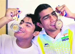 Asian Boxing Championship silver medallist Thokchom Nanao Singh and bronze medallist Jitender Kumar kissing their medals on their return in New Delhi on Tuesday.