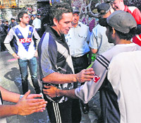 Australian cricketer Brad Hodge (C) congratulates Indian students after their match against police officers in a game of laneway cricket in Melbourne on Friday to promote a message of harmony following a spate of attacks on Indian students.