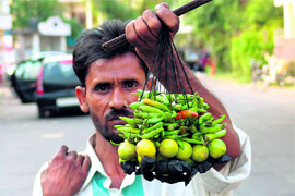 Pramod Kumar who sells black strings beaded with green chillies, lemons and coal in Jammu. These strings are treated as an omen for good luck.