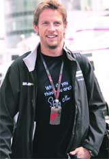 Brawn Formula One driver Jenson Button of Britain arrives in the paddock at the Nuerburgring race track