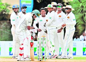Rangana Herath (4th L) celebrates the dismissal of Shoaib Malik with teammates during the third day of the second Test