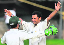 Pakistan cricketer Danish Kaneria (R) celebrates after dismissing Lankan batsman Tillakaratne Dilshan during the second day of the third and final Test match in Colombo on Tuesday. 
