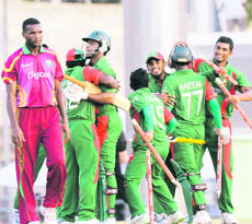 West Indies bowler David Bernard Jr walks away as Bangladesh players celebrate their series win after clinching the second ODI at Windsor Park, Dominica, on Tuesday.