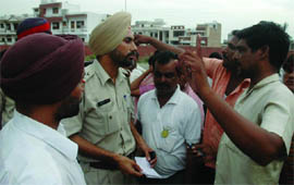Residents of Dhobiana Basti speaking to Gurdeep Singh, in-charge of the Civil Lines police post in Bathinda on Monday.