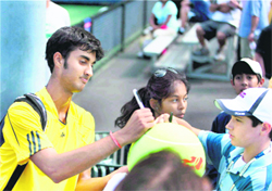 Yuki Bhambri gives autographs after winning against Jordan Cox on Sunday.