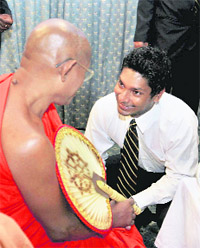 Sri Lankan cricket captain Kumar Sangakkara (R), speaks with a Buddhist monk before leaving for South Africa to take part in the ICC Champions Trophy on Wednesday. � AP/PTI