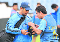 Fitting It Right: Mahendra Singh Dhoni (L) checks Sachin Tendulkar�s helmet during a training session in Centurion 