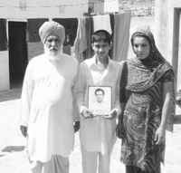 Nachhattar Singh along with his daughter-in-law and grandson at his house in Tallewal village 