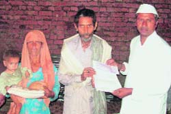 Dinakar Atma Ram Surte, a cotton trader from Maharashtra, gives a demand draft to Kura Ram in Mirzapur village, near Pathankot.