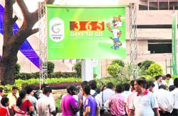People walk in front of the newly-unveiled Commonwealth Games Clock in New Delhi on Saturday.