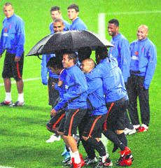 Dutch players take cover from rain during a training session in Sydney on Friday.