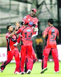 Trininad and Tobago's players celebrate the fall of the wicket of a Somerset batsman during the Champions League T20 match at Chinnaswamy Stadium in Bangalore