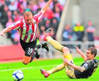 Sunderland�s Lee Cattermole (L) is fouled by Liverpool�s Daniel Agger at The Stadium of Light, in Sunderland, north-east England