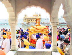 Devotees participate in a religious procession held in connection with the birth anniversary of Guru Nanak Dev at the Golden Temple in Amritsar on Saturday.