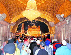 Devotees throng the illuminated Golden Temple to pay obeisance on the eve of Gurpurb on Sunday. 