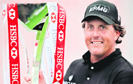 US golfer Phil Mickelson holds the trophy after winning the HSBC Champions golf tournament in Shanghai on Sunday.