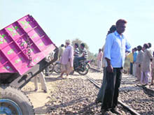 Villagers at the scene of the accident between a train and a tractor-trailer (left) near Bakayanwala on the Abohar-Sriganganagar rail section on Thursday.
