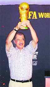 Seychelles President James Michel lifts the FIFA World Cup on its arrival in Victoria on Sunday.
