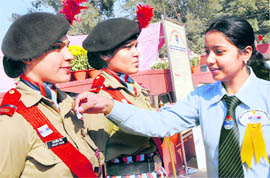 A volunteer pins a flag on the uniform of an NCC cadet at the Punjab State War Memorial in Jalandhar on Armed Forces Flag Day on Monday.