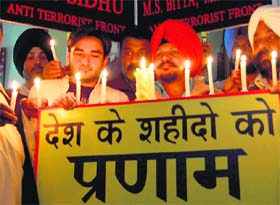 Members of the All-India Anti-Terrorist Front hold candles as they pay tributes to the victims of theParliament attack on its eighth anniversary, in Amritsar on Sunday.