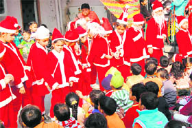 Schoolchildren dressed as Santa Claus distribute sweets in Amritsar on Thursday