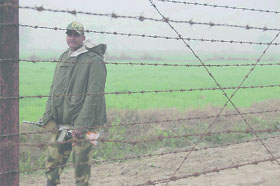 Unmindful of the fog and cold weather, a BSF jawan keeps vigil on the India-Pakistan border on Friday. 