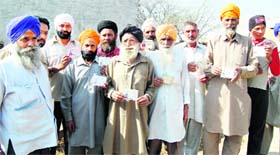 Farmers of Rorawala village, Attari, show the identity cards issued to them which will be soon replaced with new ones