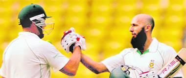 Hashim Amla (R) celebrates after completing his century with teammate Jacques Kallis in Nagpur on Saturday.