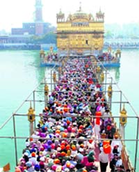 Devotees outside the Golden Temple pay obeisance on the first day of the year as per the Nanakshahi caldender in Amritsar on Sunday. Tribune photograph: Vishal Kumar